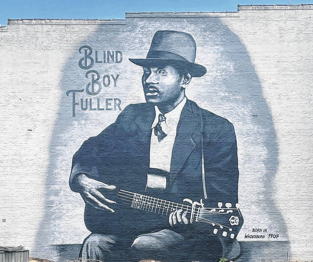 128421159_web1_FullerMural
Artist Scott Nurkin of The Mural Shop has completed his mural of Wadesboro-native and blues legend Blind Boy Fuller on the blank side of the Belk building on North Green Street in Wadesboro. Nurkin has been working on a series of murals honoring famous musicians in the North Carolina towns where they were born. Fuller, birth name Fulton Allen, was born in Wadesboro on July 10, 1907 and died in Durham on Feb. 13, 1941. Though he was one of the most recorded artists during his time, most of his work was produced over a six-year span, according to AllMusic.com. Still, he became one of the most influential artists of the region playing styles such as slide, ragtime, pop and blues.
Contributed photo