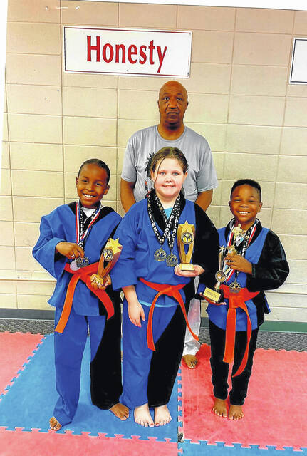 Three members of the Ebony Dragon competition team won trophies and medals at a championship event held in Dillon, S.C. Pictured are Tre Garth, Addison Jarrell and Christian Garth with Sensei Covington.
                                 Submitted photo